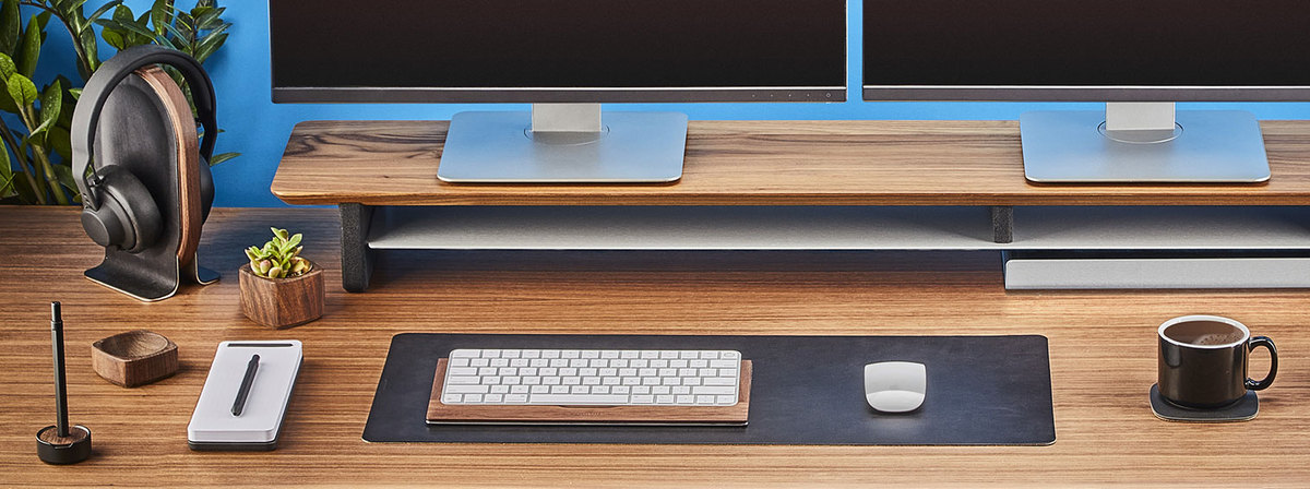 Photo of desk with grovemade products displayed: headphone stand, desk pad, desk shelf, pen